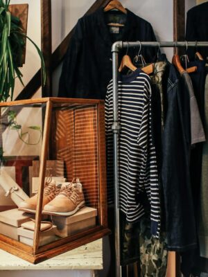 A stylish boutique clothing rack featuring diverse apparel and accessories in a cozy, natural setting.